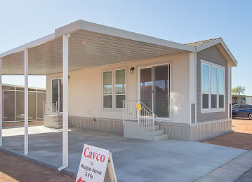 Exterior view of a manufactured home with a large front window at Cotton Lane RV Resort.
