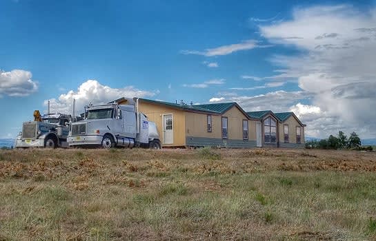 Transport trucks with manufactured homes on rural site