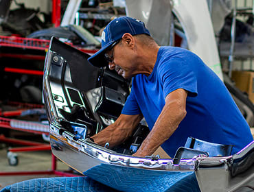 A worker inspecting repairs in the body shop.