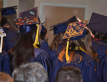Graduates in caps and gowns at a graduation ceremony, representing student success and scholarship opportunities