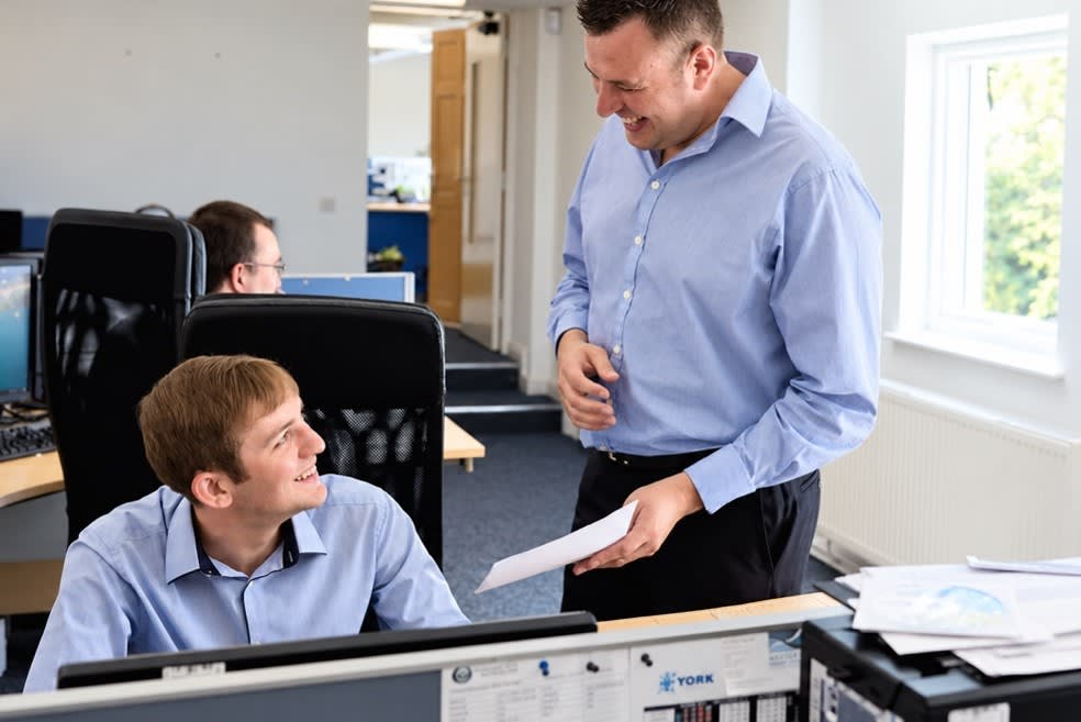 Two men talking and laughing in an office