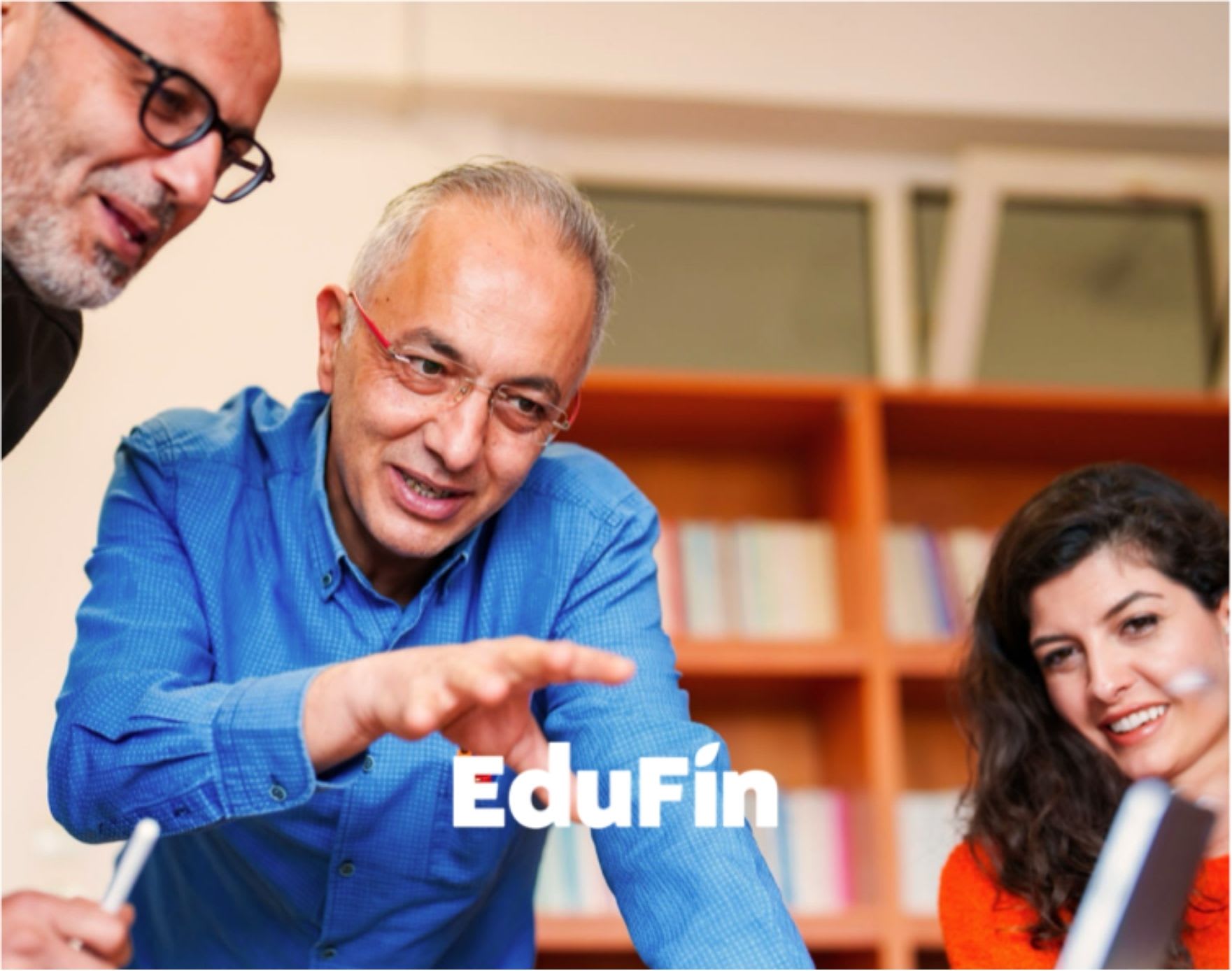 Two men and a woman talking around a computer