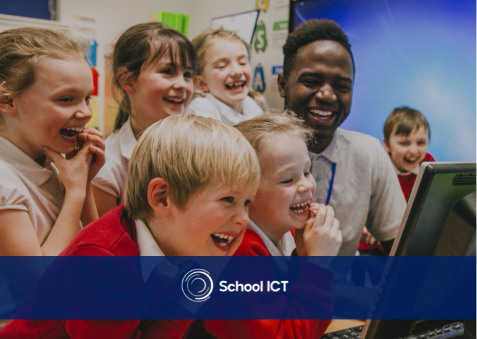 Man with classroom of children laughing around computer