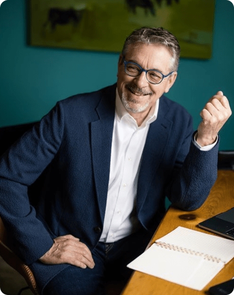 man smiling sat a desk