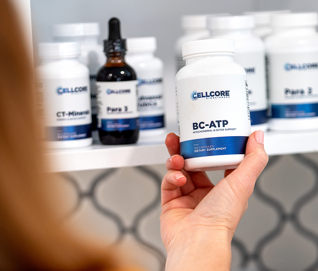 CellCore BioToxin Binder supplement bottle on a wooden surface with lavender and apothecary bottles
