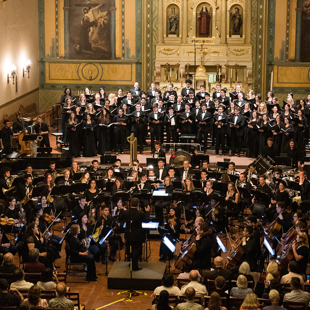 a choir and orchestra in performance inside a church