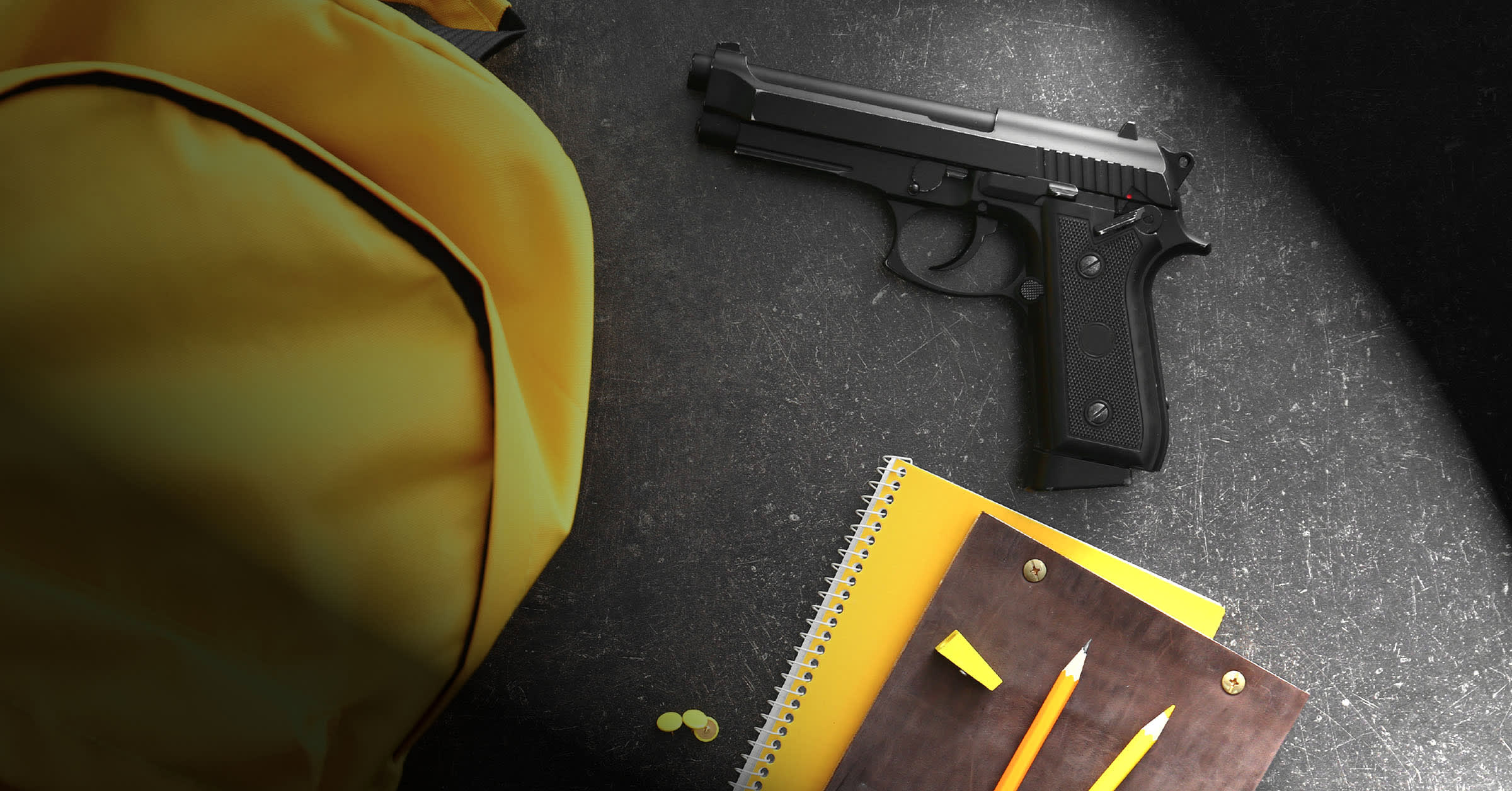 a yellow backpack, yellow notebook, two pencils, and a gun