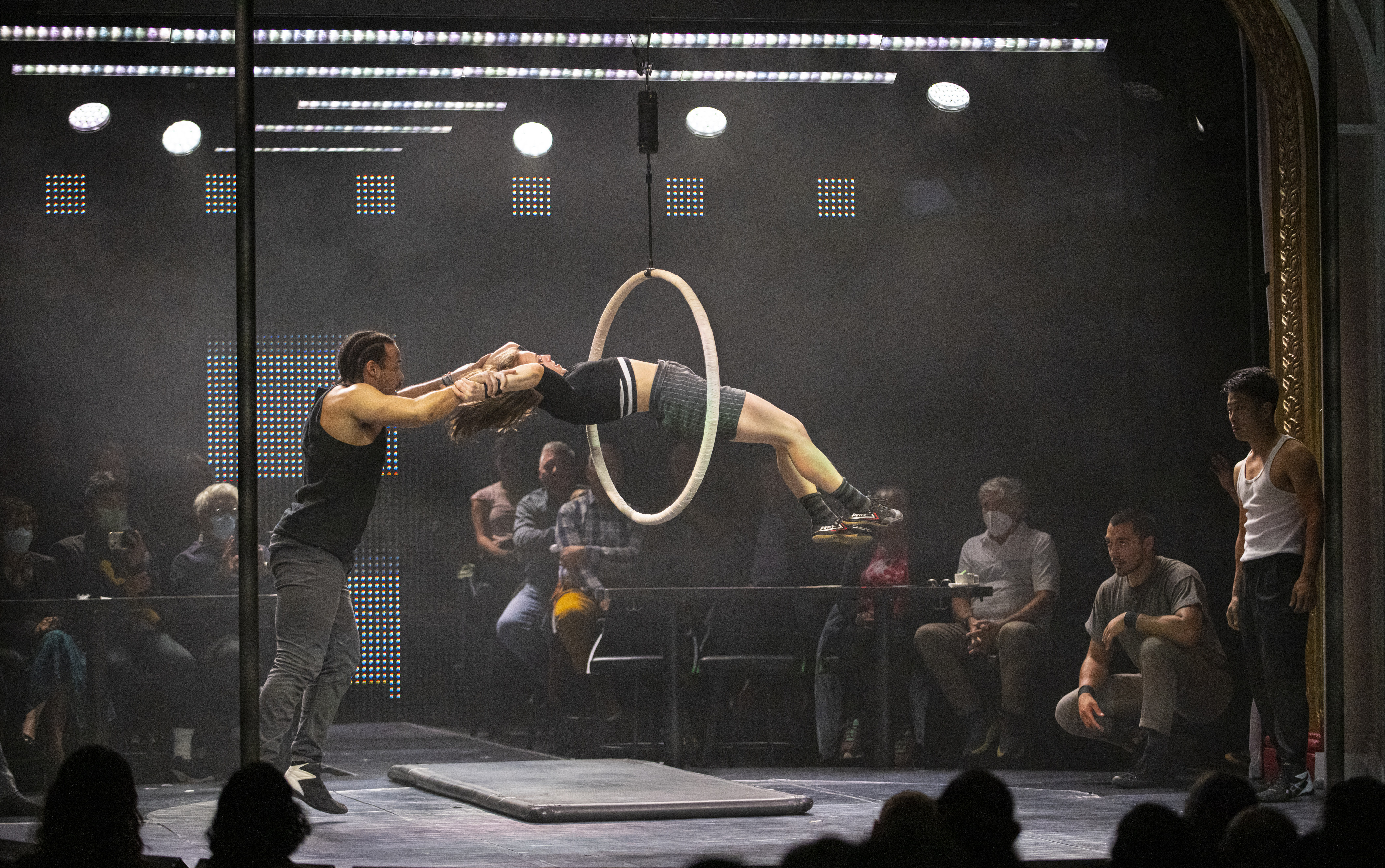 An acrobat leaps through a hoop with the help of another acrobat during a Dear San Francisco performance