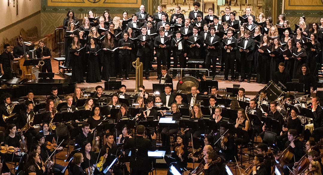 a choir and orchestra in performance inside of a church