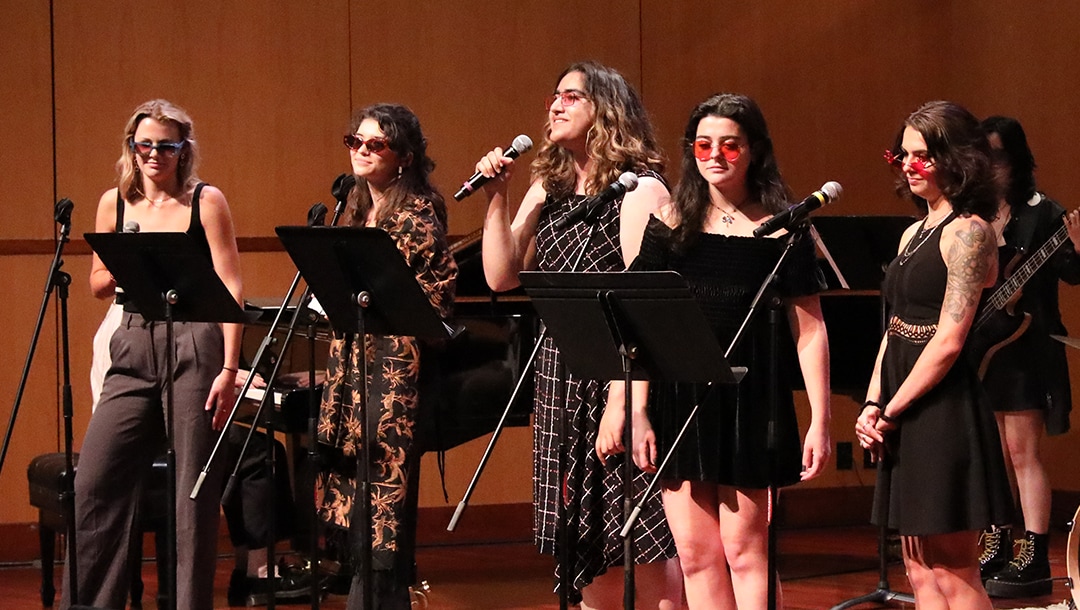 five singers with music stands wearing sunglasses