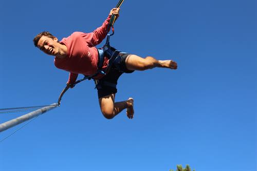 young man flying high on bungee bounce