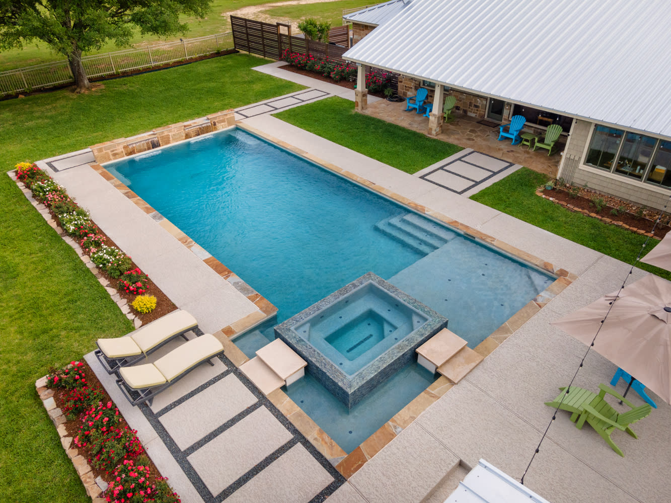 Custom rectangular pool with raised spa and waterfall features in Bellville, Texas by Sunset Pools
