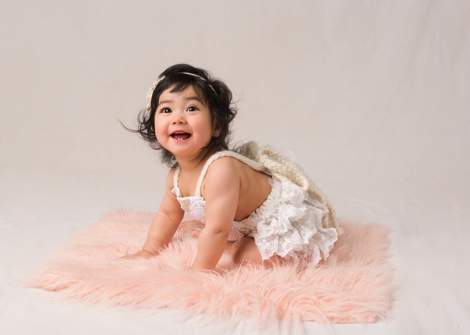 7 month old girl in boho romper. Cream background