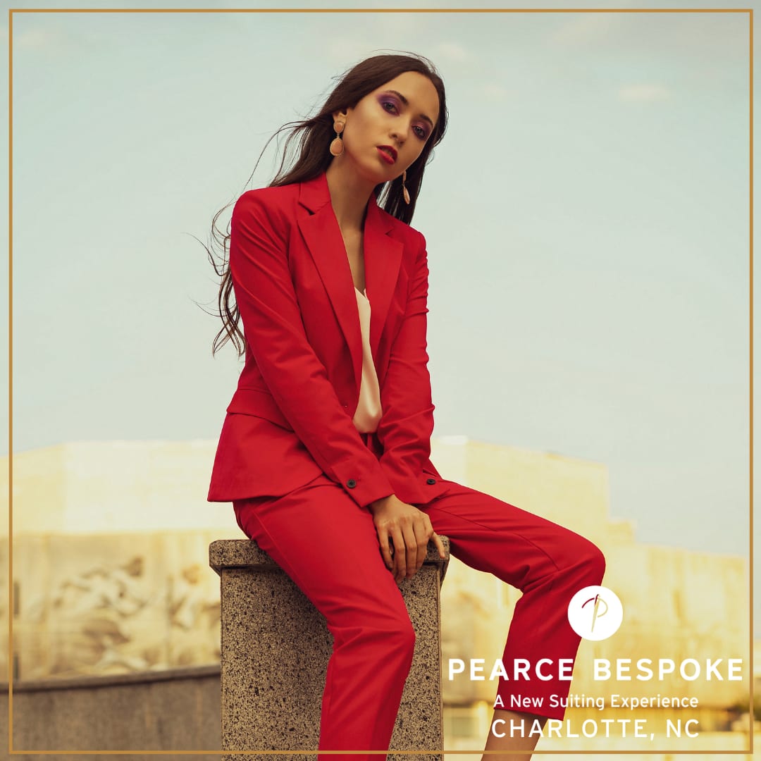 A confident woman wearing a custom red power suit from Pearce Bespoke Charlotte, showcasing bold style and impeccable tailori