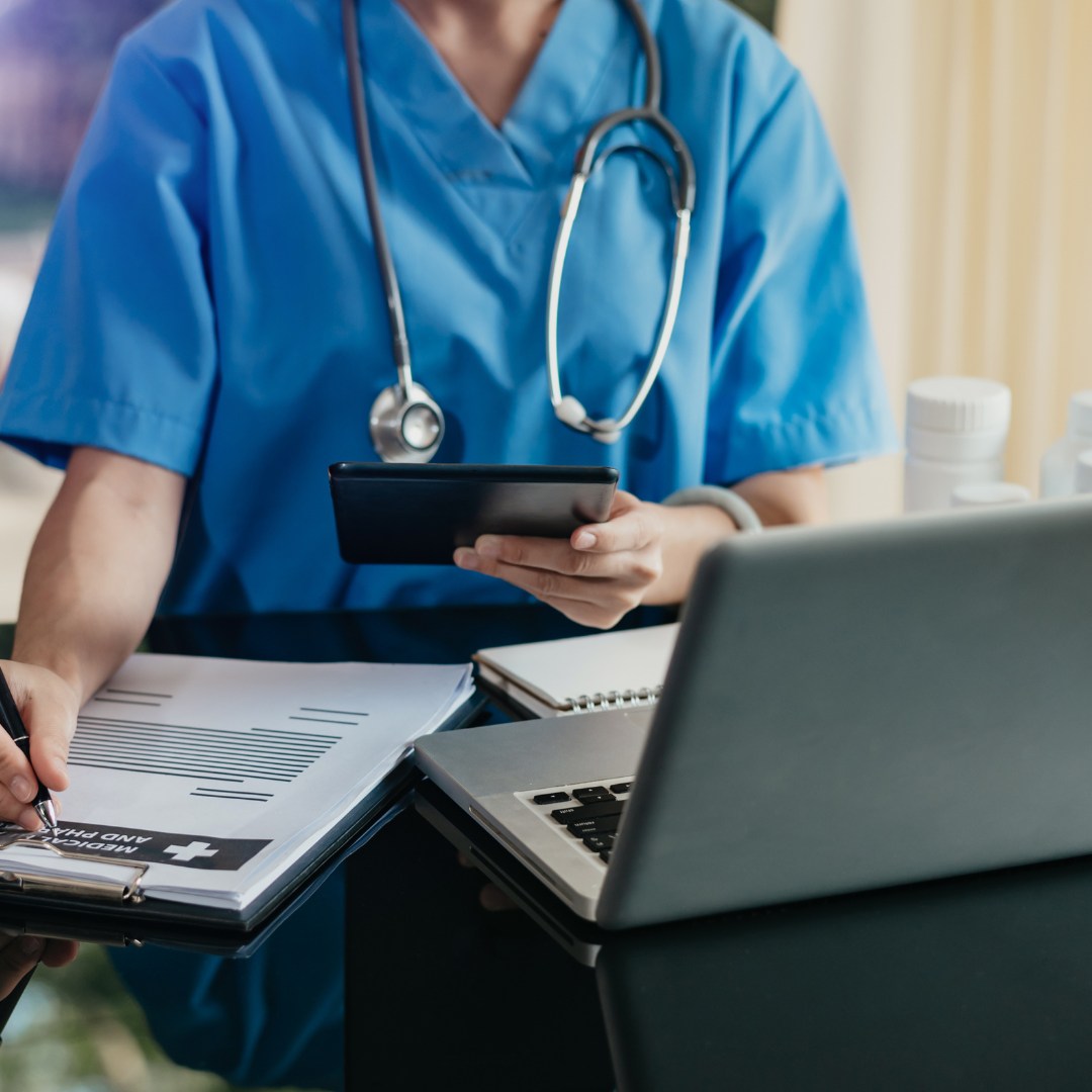 A medical person reviewing notes in front of a computer