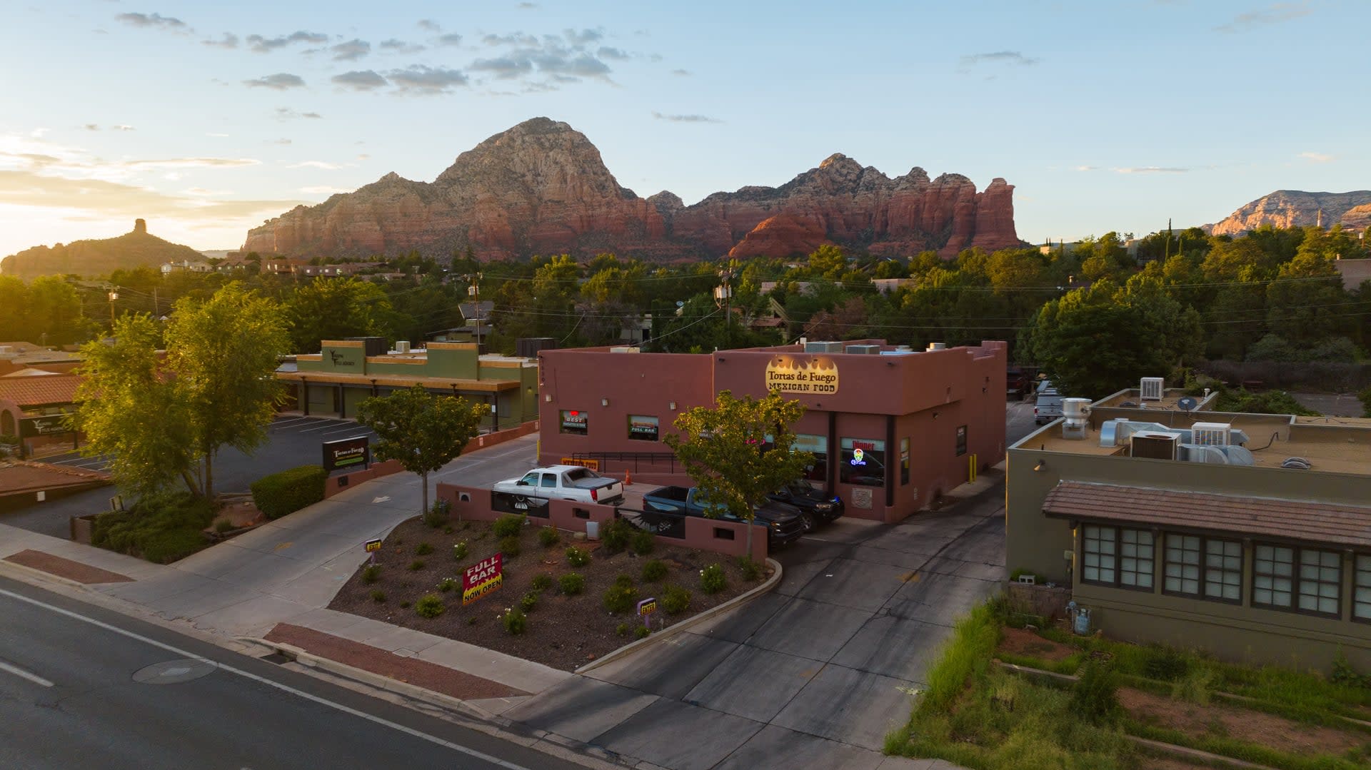 Aerial view of Tortas de Fuego Mexican Food in West Sedona with red rock formations and neighborhood buildings at sunset.