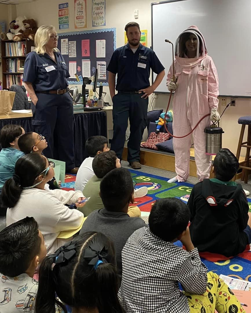 Colburn's Pest Control Technicians (one in a bee suit) teaching kids about exterminating at a school career day