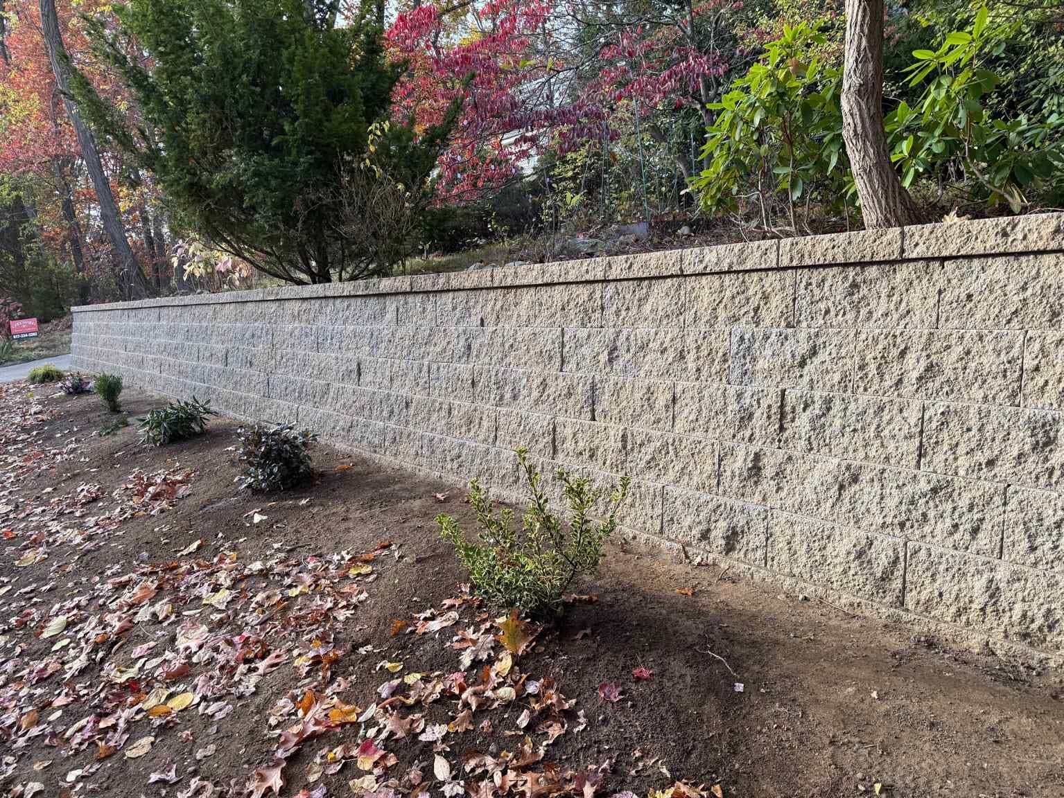 Retaining wall installation in Newton, MA built for slope support and erosion control — Goodwood General Construction.