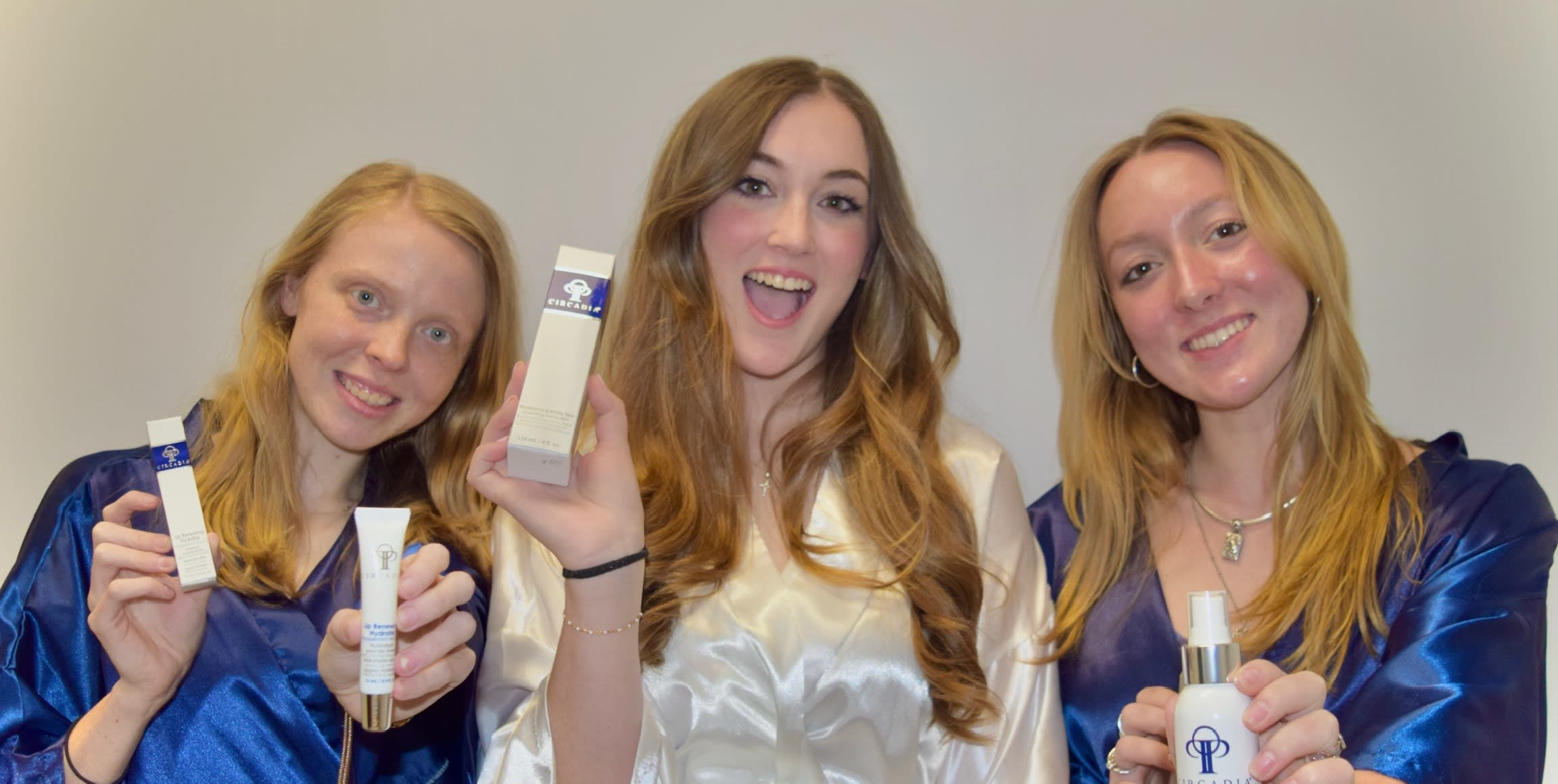 Three women smiling and holding up Circadia skincare products, showcasing their favorite medical-grade skincare at the spa.