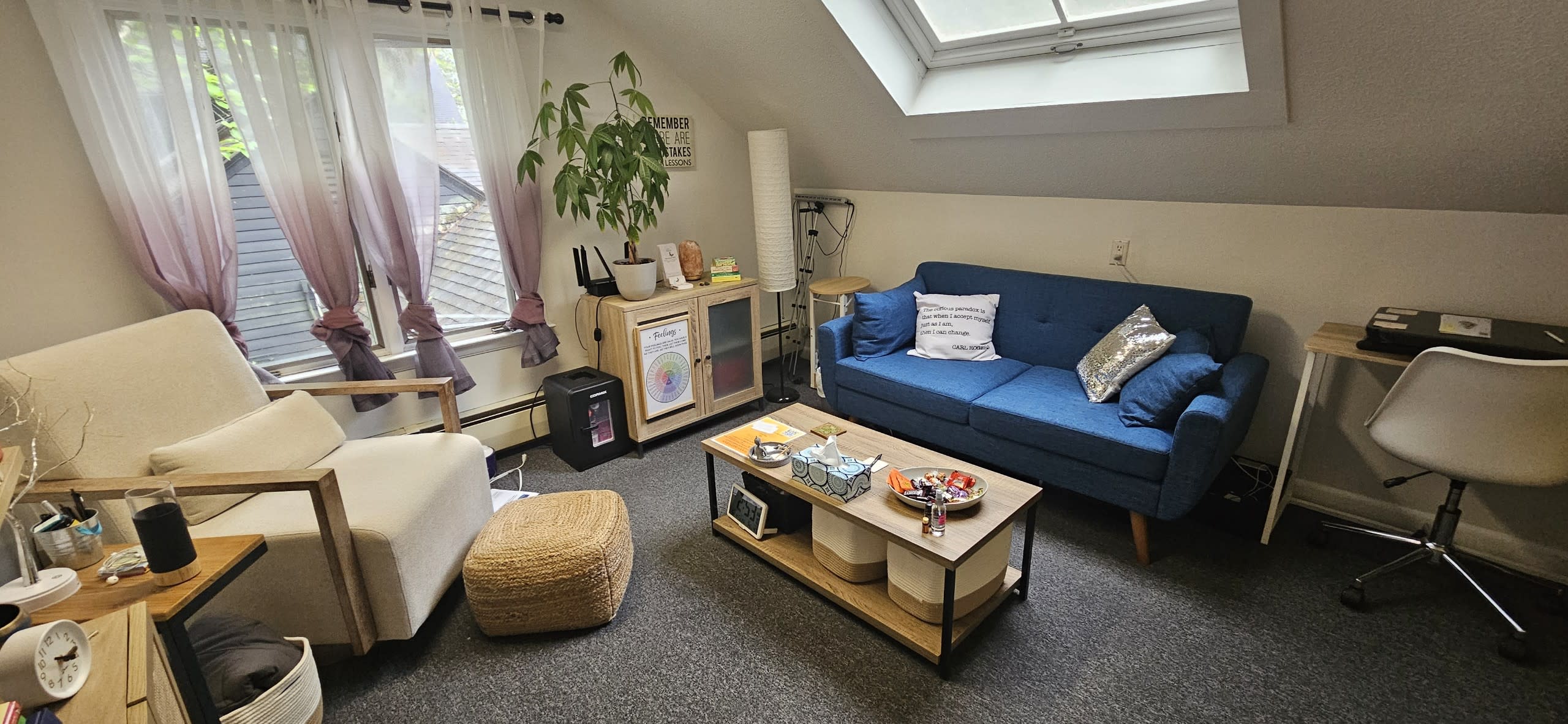 office at 304 Main Street a blue couch, a white chair a coffee table and a plant