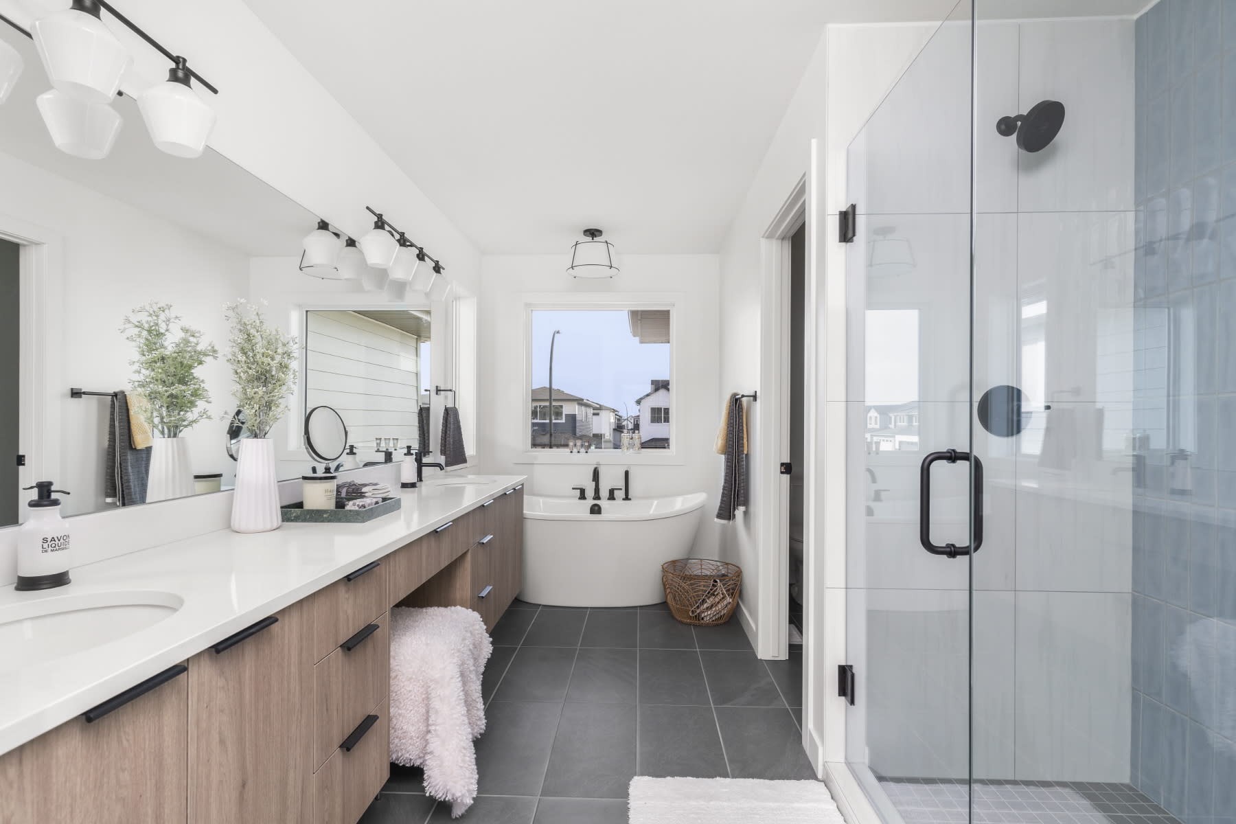 A spa-like primary ensuite featuring a custom tile shower and a freestanding tub, offering a luxurious and relaxing retreat.