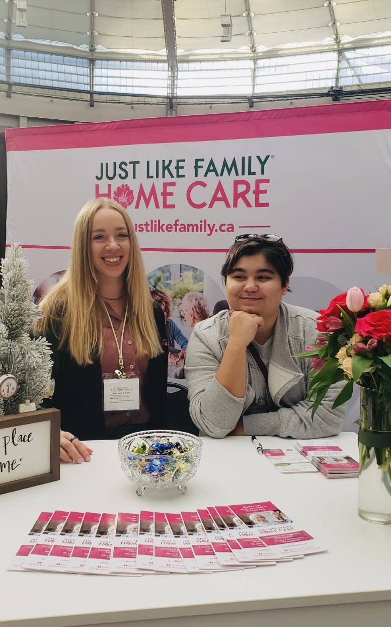 A couple JLF staff manning a booth around Christmas 2023