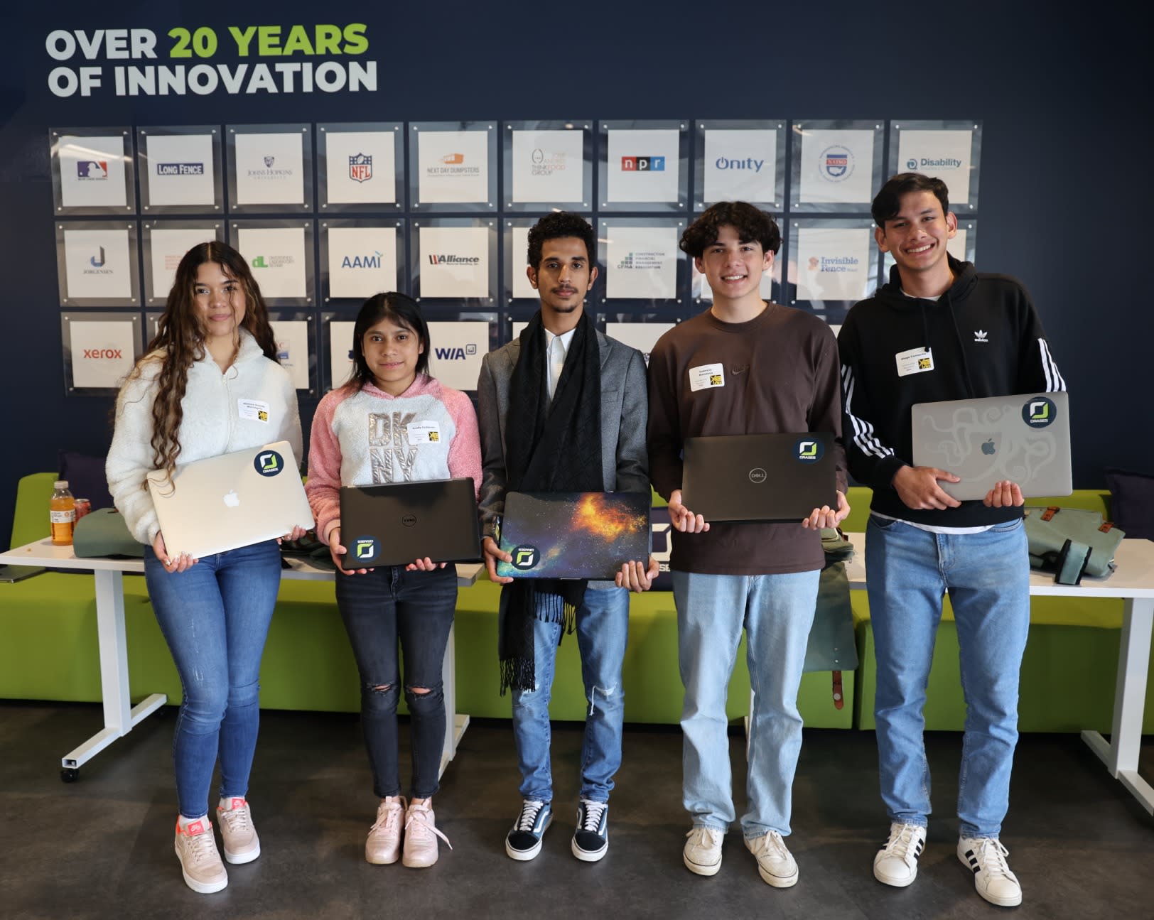 Orases presents laptops to 5 LYNX students, image of 5 students holding a laptop