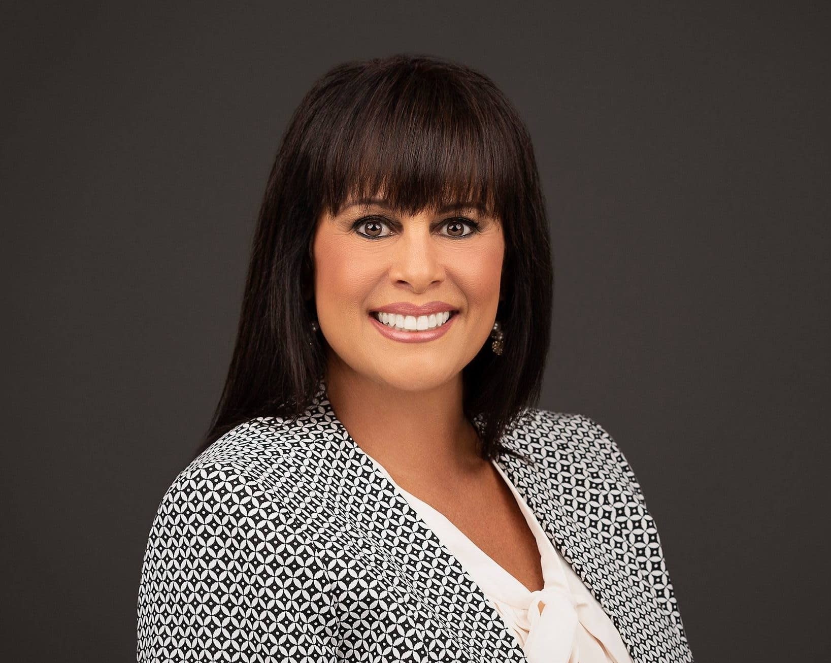 Woman in black and white polka dot blouse - Tena Caracciolo