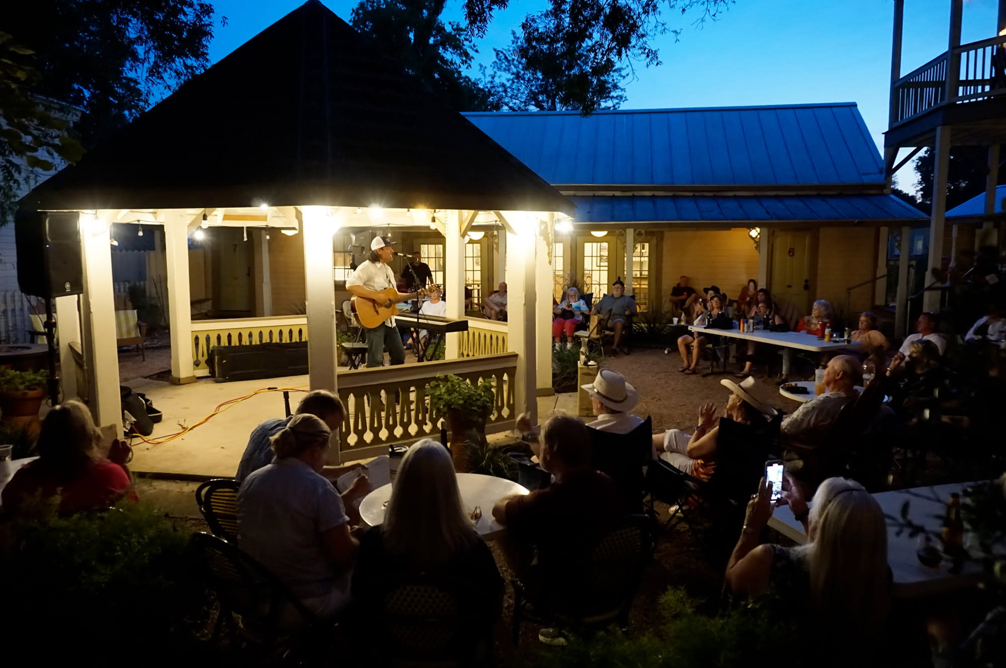 musician in lighted gazebo and crowd watching