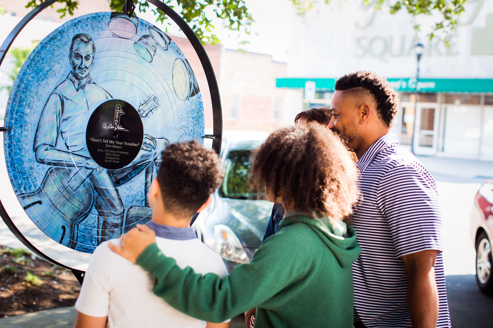 A family looks at one of the LP art displays on Washington Street.