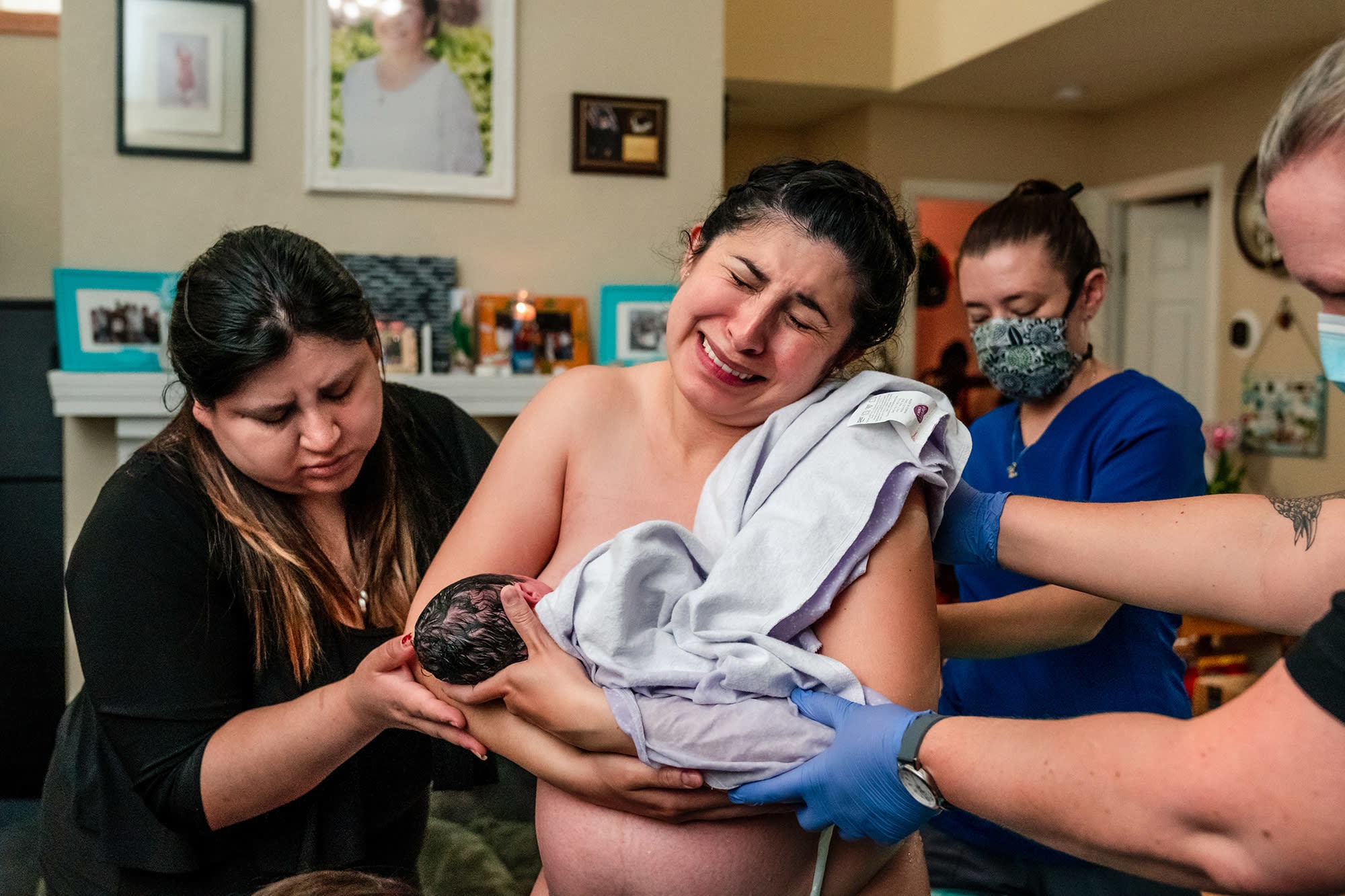 a mother emotional while holding her newborn daughter after delivery