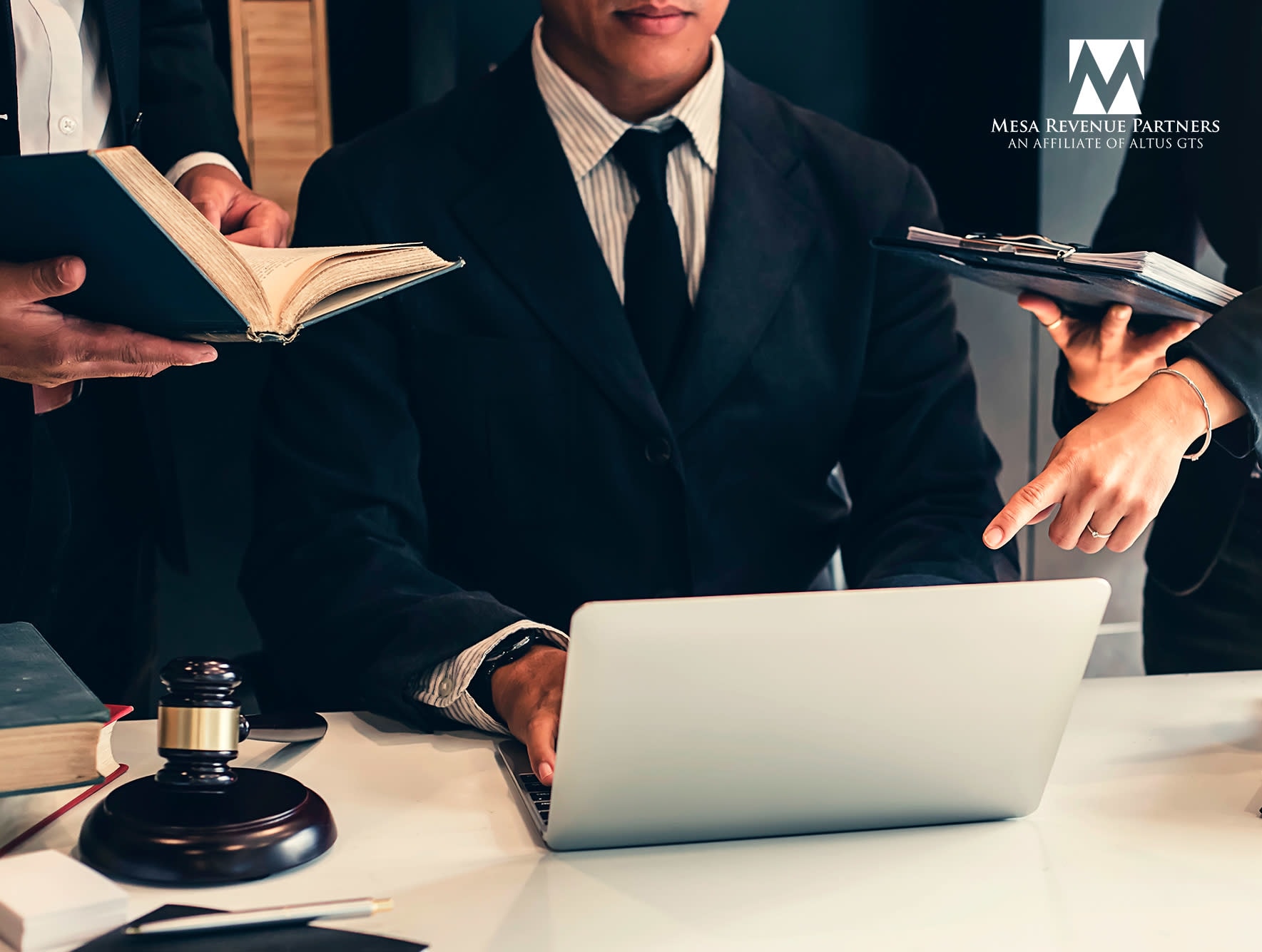 A man in a suit and tie working at a desk with a laptop, representing a corporate business environment in New York