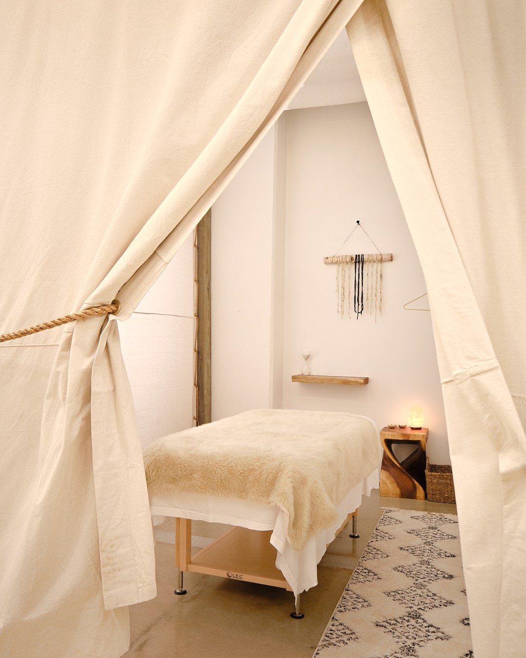 Serene massage room at The NOW Massage Oak Lawn in Dallas with soft lighting, natural textures, and cozy decor