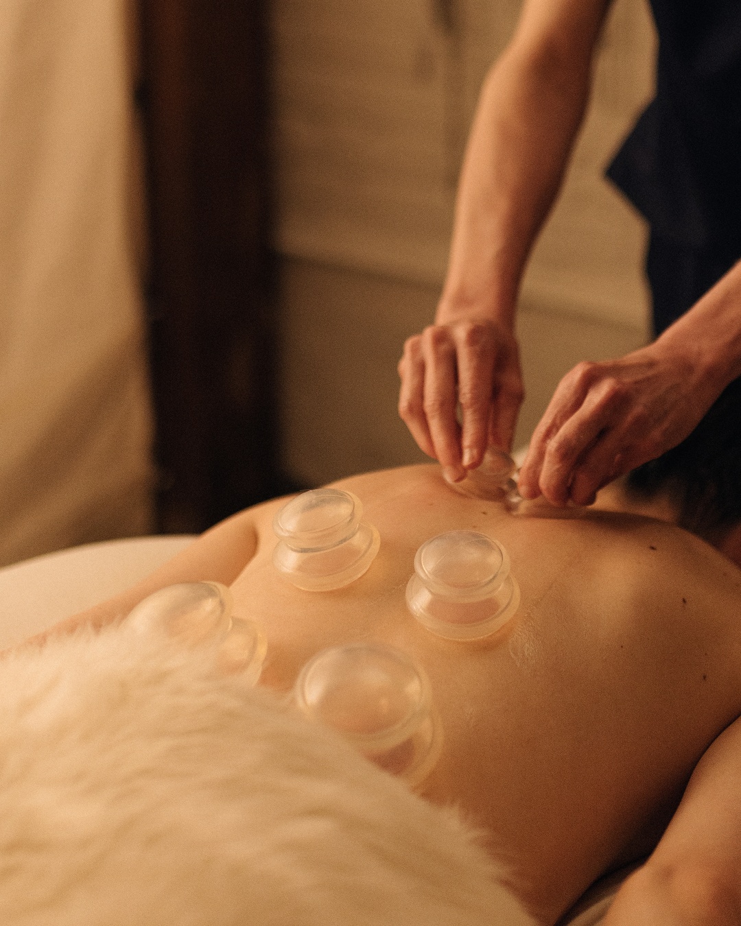 Therapist performing gliding cupping massage treatment at The NOW Massage Oak Lawn.