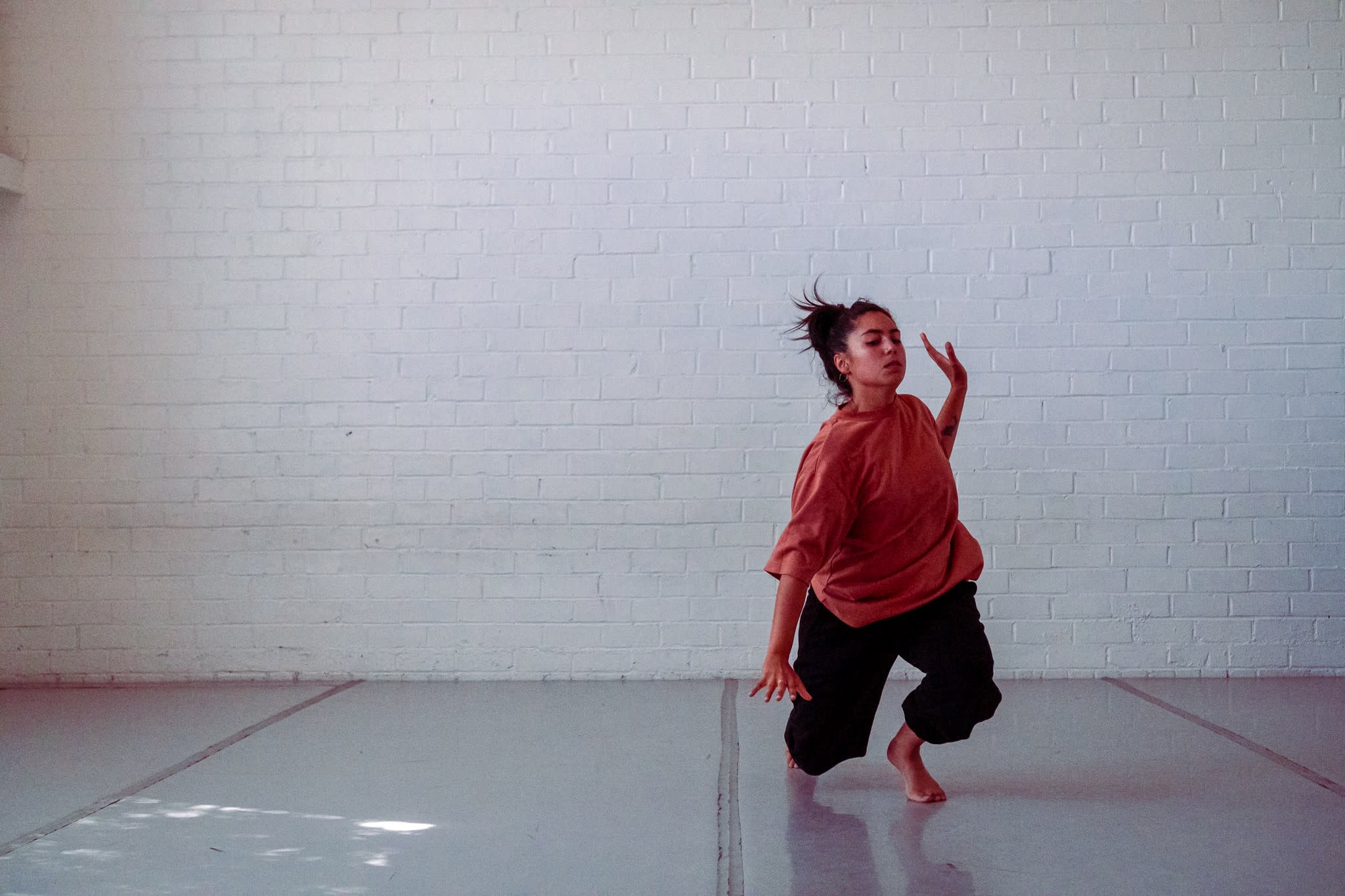 One dancer performs in the white room.