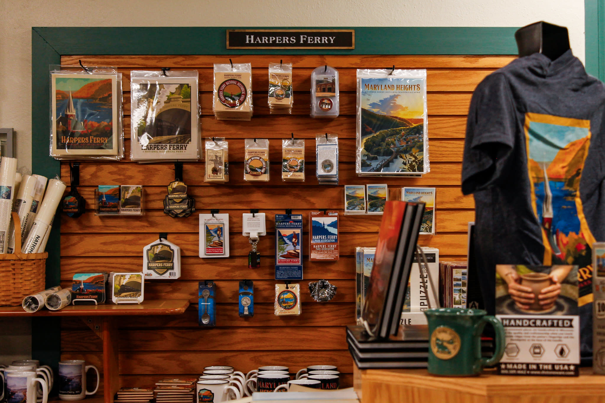 A display wall the Park Bookshop, featuring postcards, magnets, keychains, stickers, and artwork themed around the town.