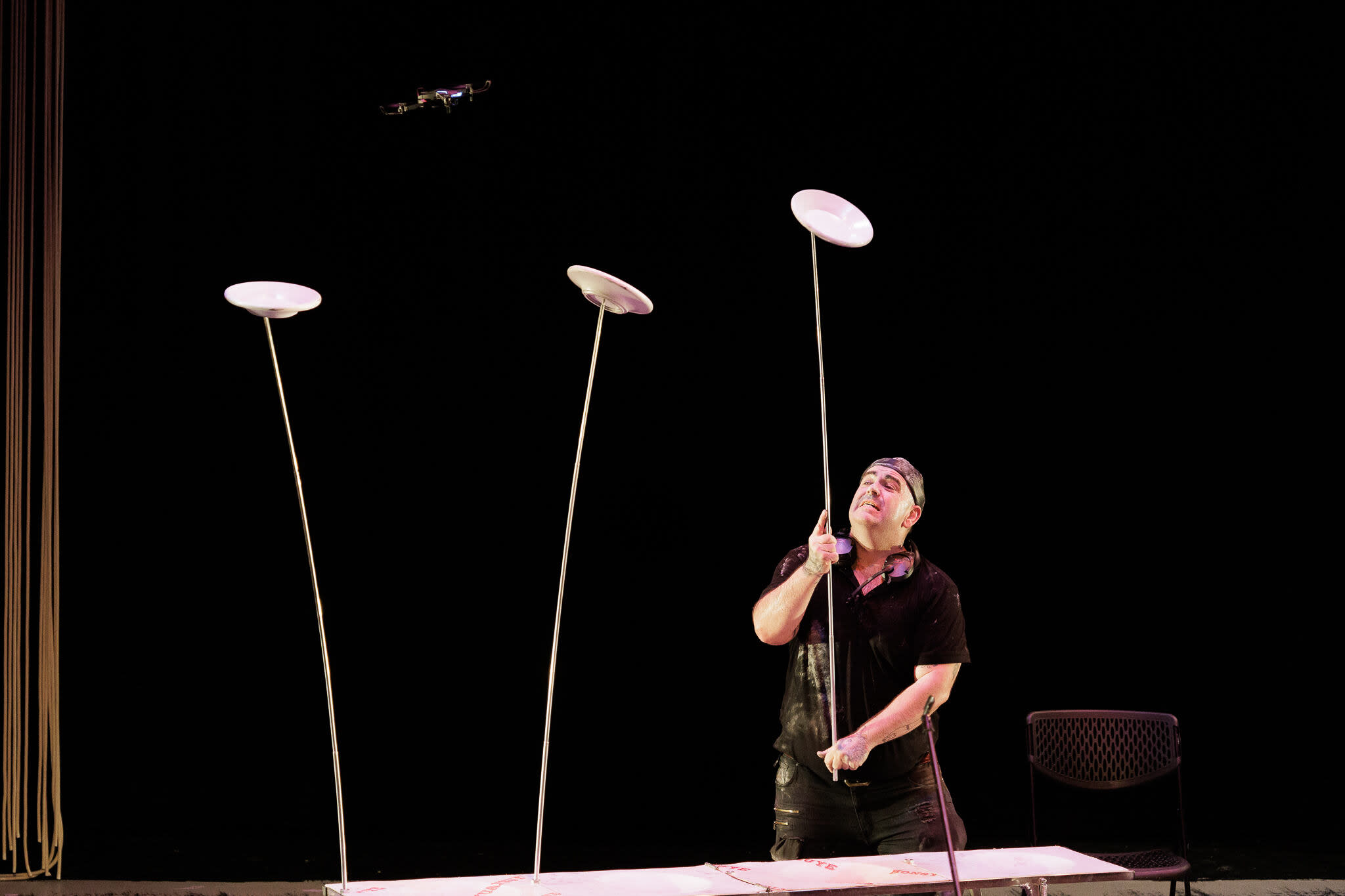 A man balancing plates on long poles