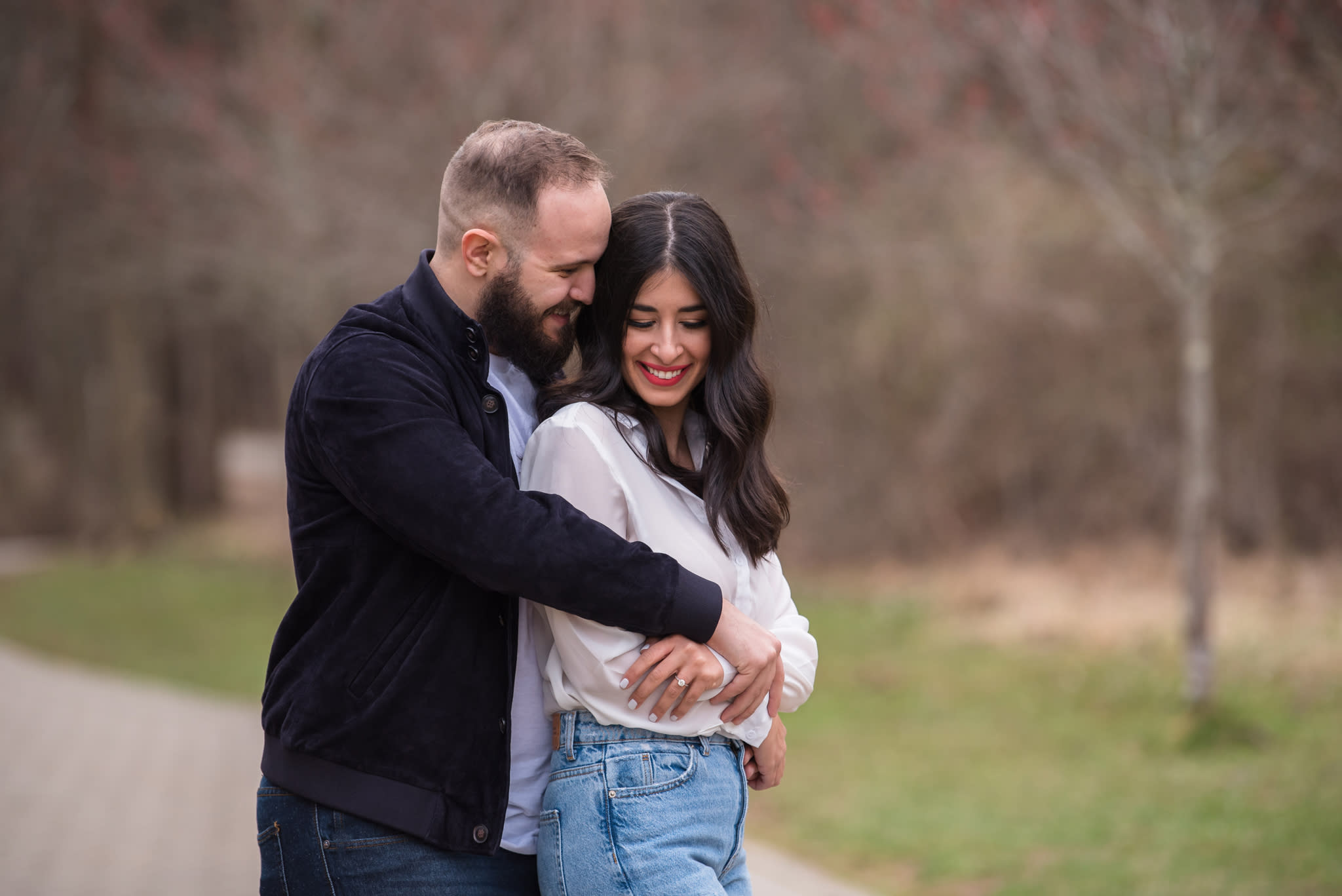 A Greek couples hugging each other at their engagement photoshoot in a park.