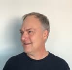 A man wearing a black shirt looks to his right.