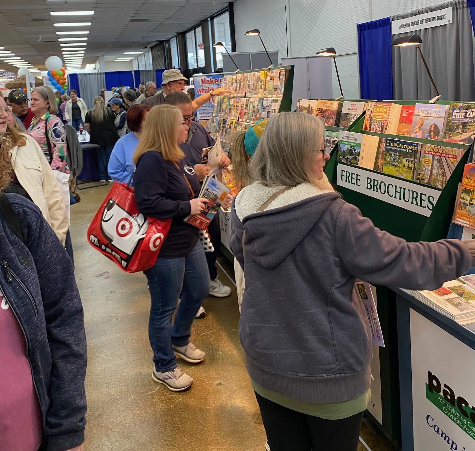 Showgoers look at brochures on racks