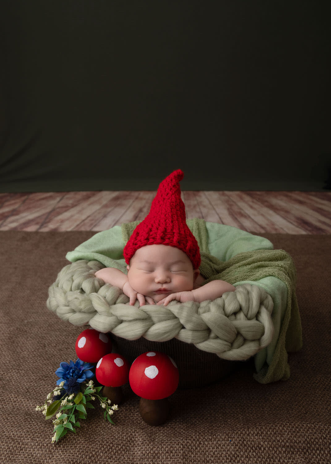 Newborn Boy In Gnome Hat Chin On Hands In Bucket