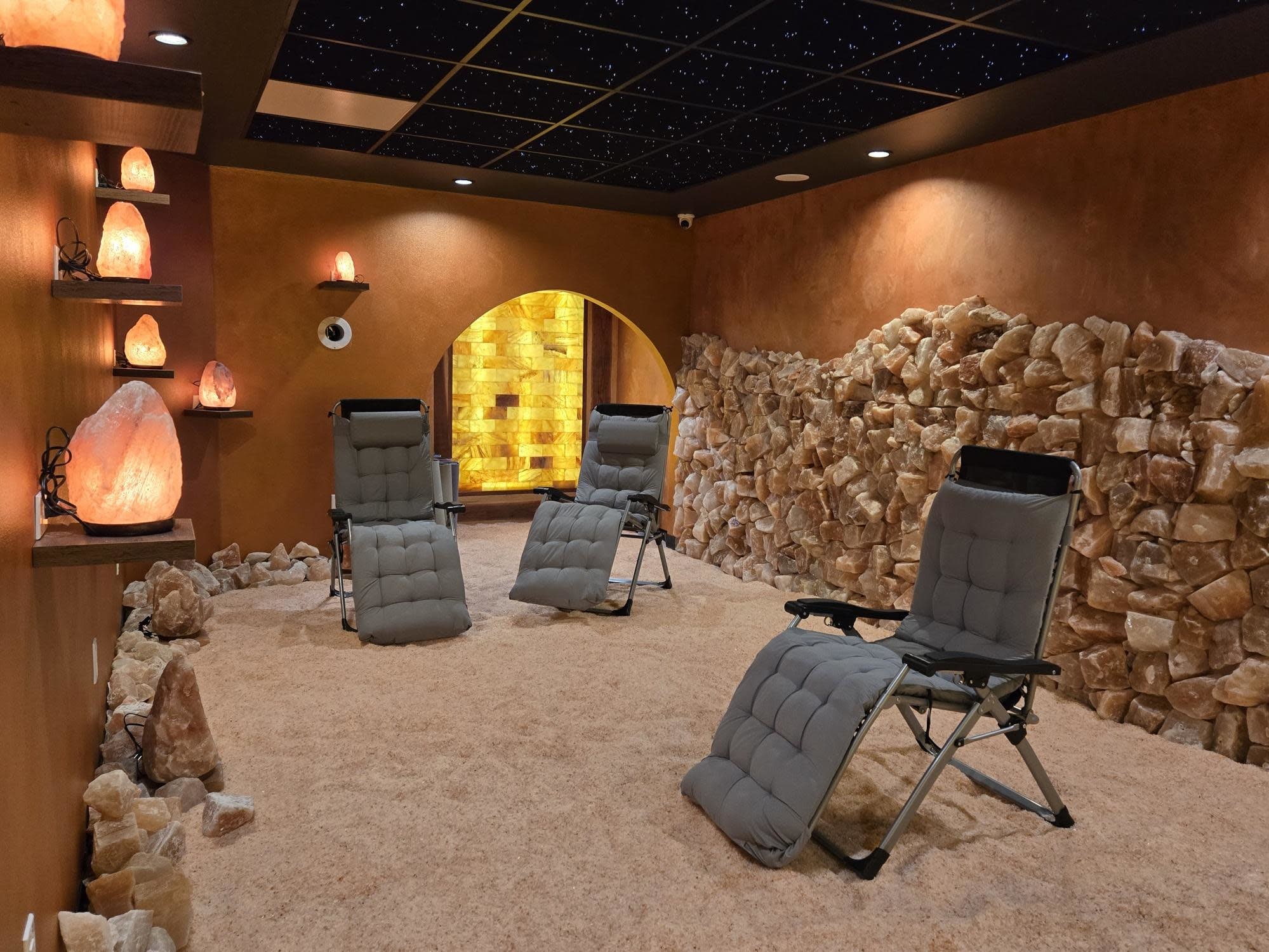Himalayan salt lined cave with reclining chairs and pink salt lamps