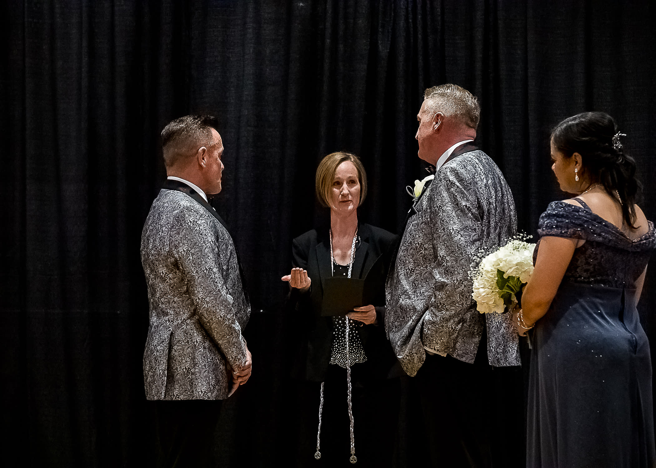 officiating wedding ceremony, two grooms and one bridesmaid