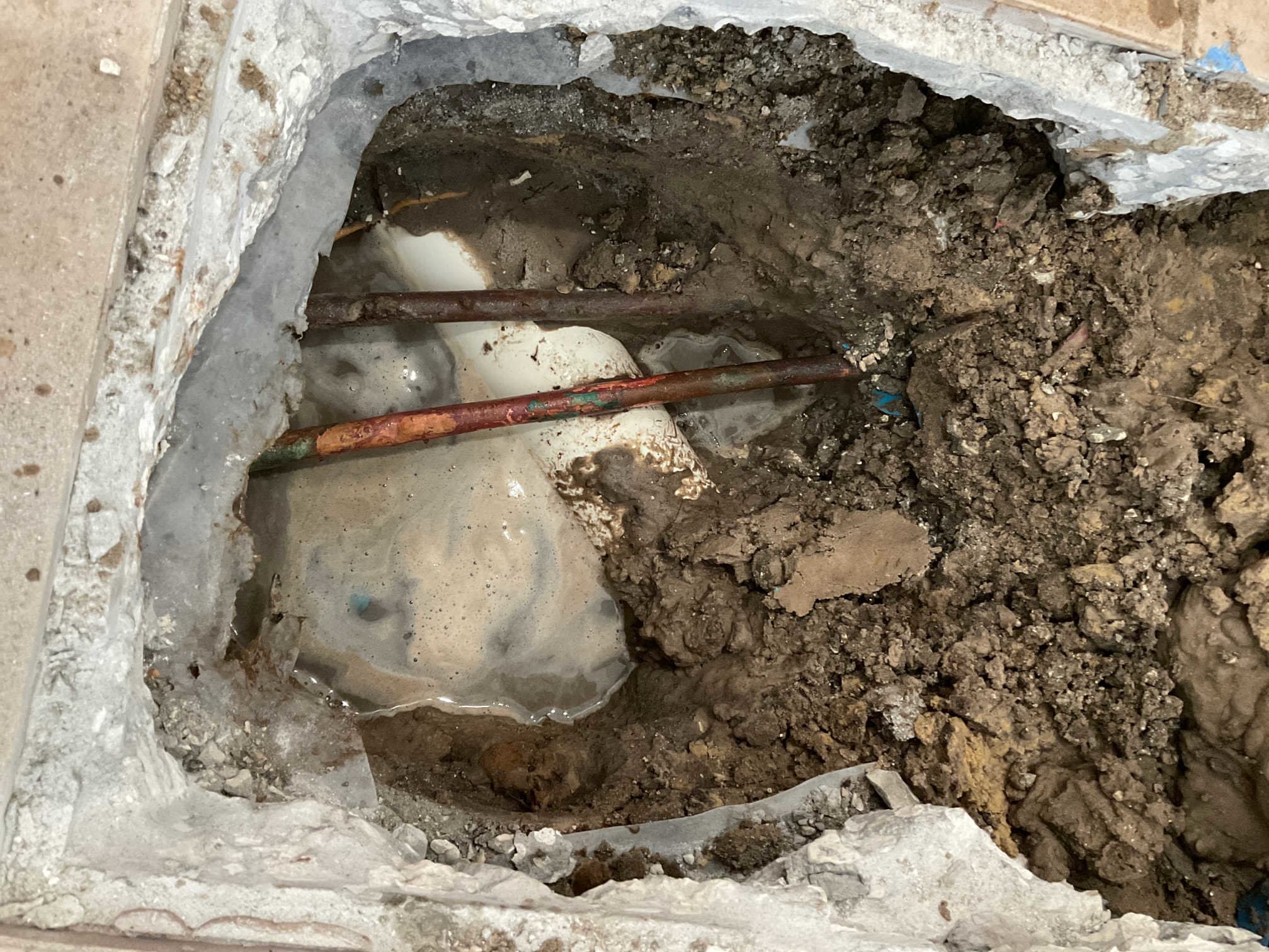 Slab leak repair with exposed copper lines and PVC under concrete in a St. Petersburg home