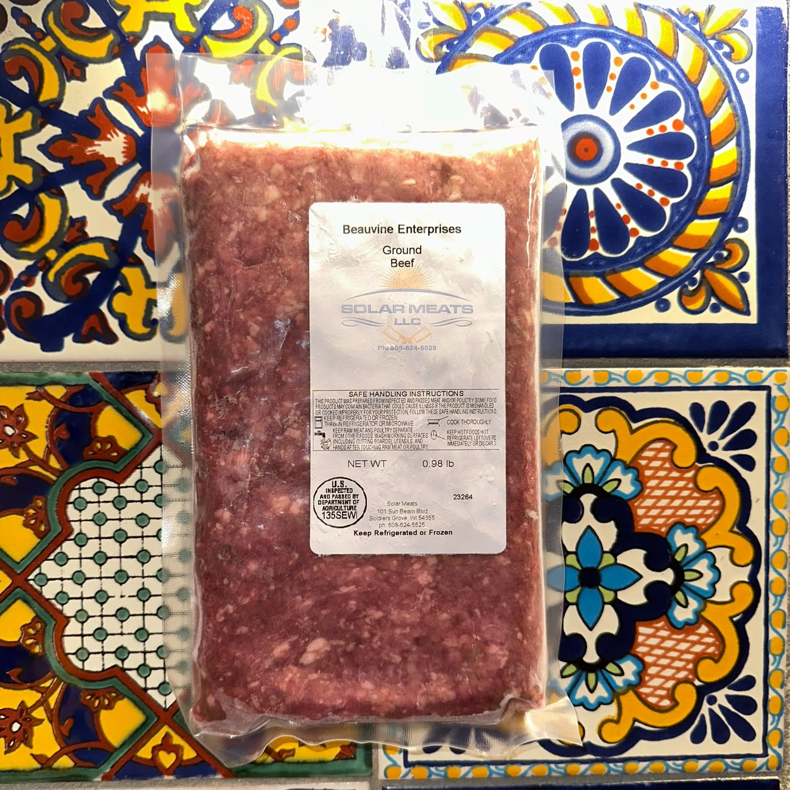 package of ground beef on background of talavera tiles