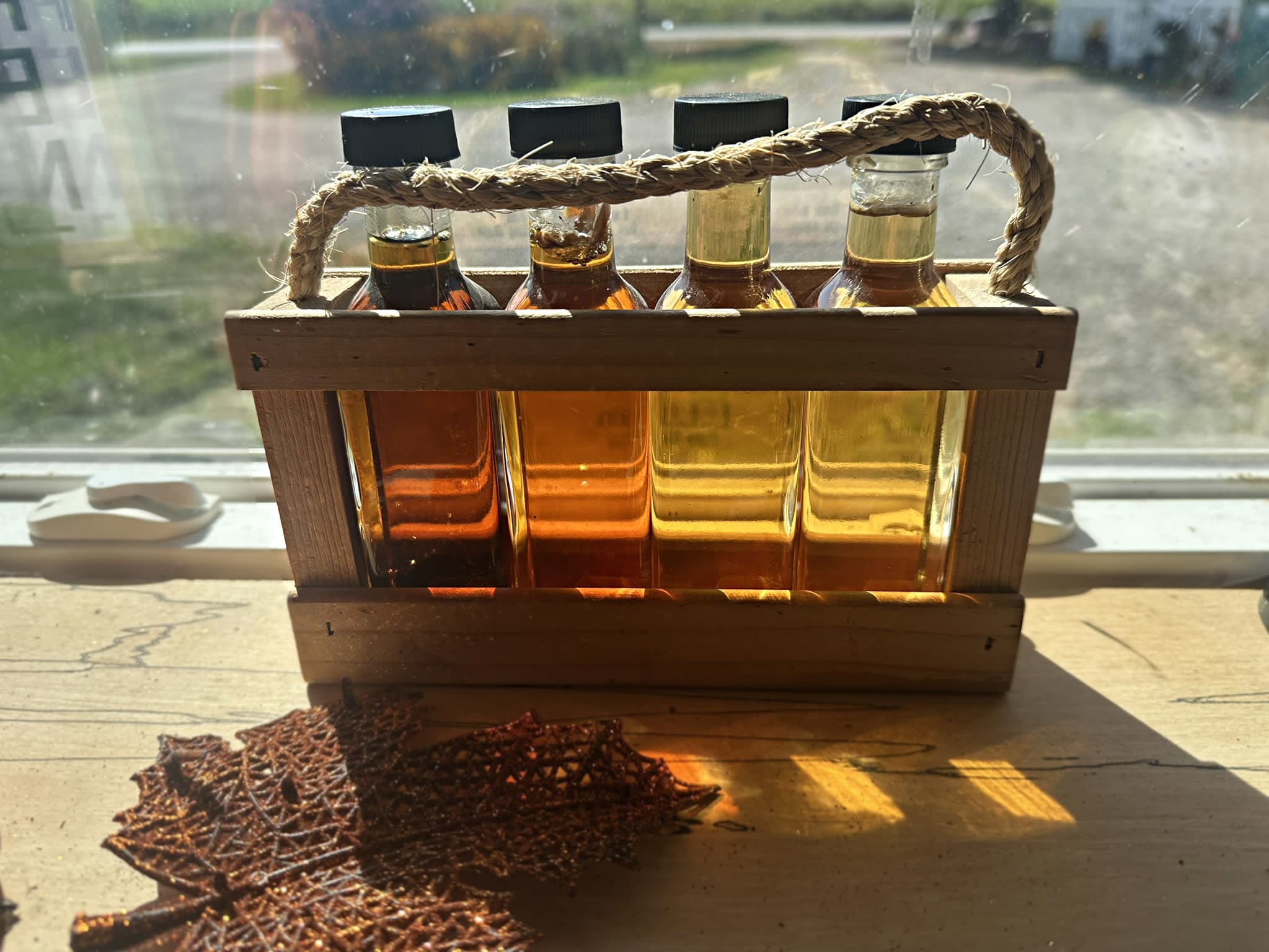 Photo of the different grades of maple syrup, ranging from a dark amber to a light golden color
