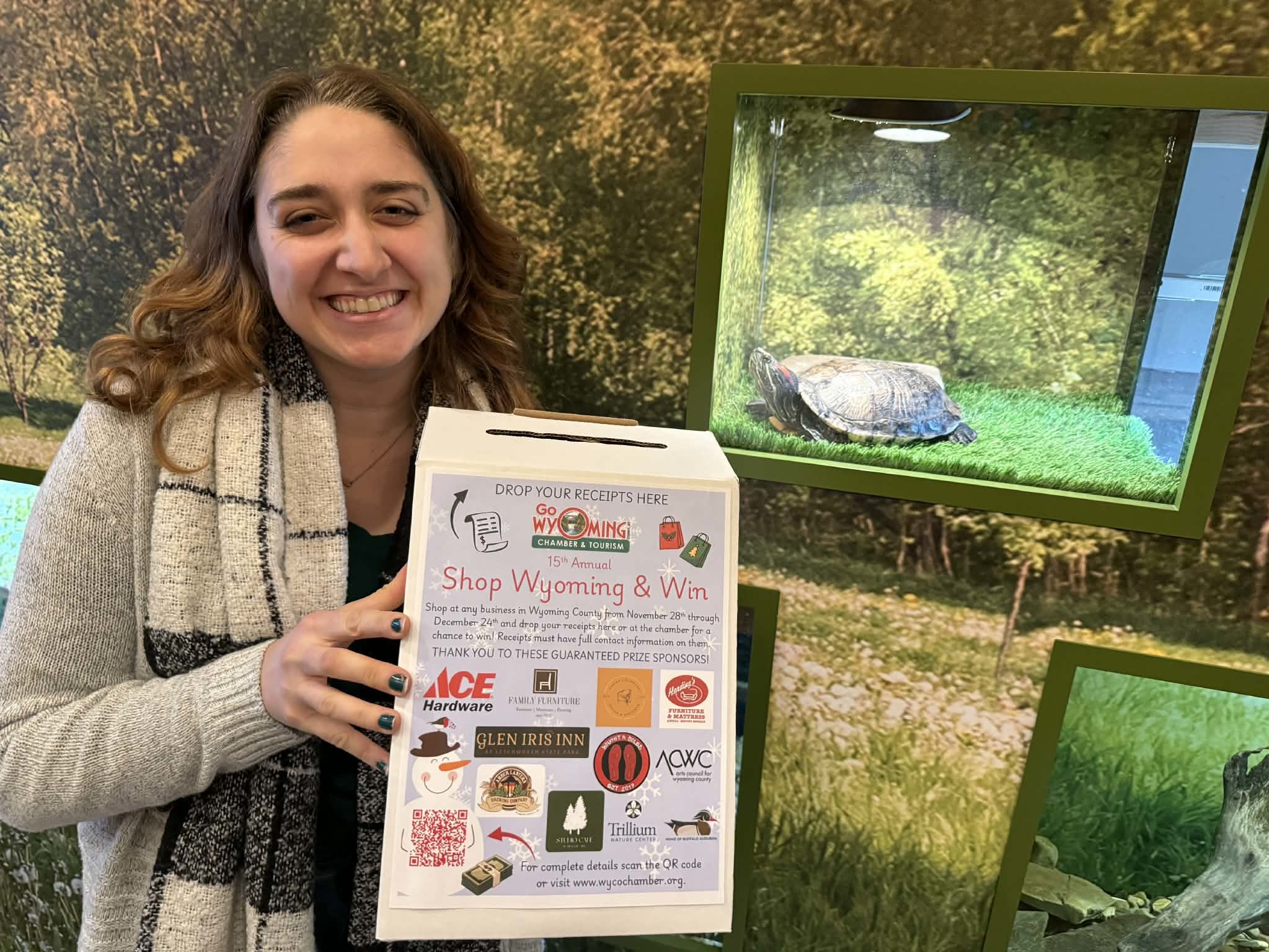 person holding shop wyoming and win box in front of a turtle enclosure