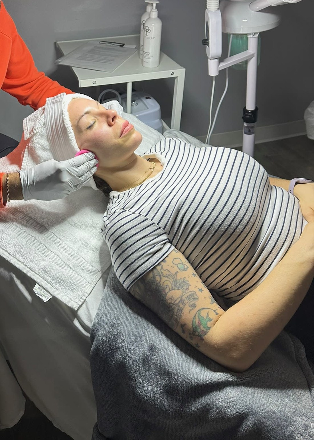 Woman receiving a professional facial treatment at a medical spa, lying relaxed with eyes closed.