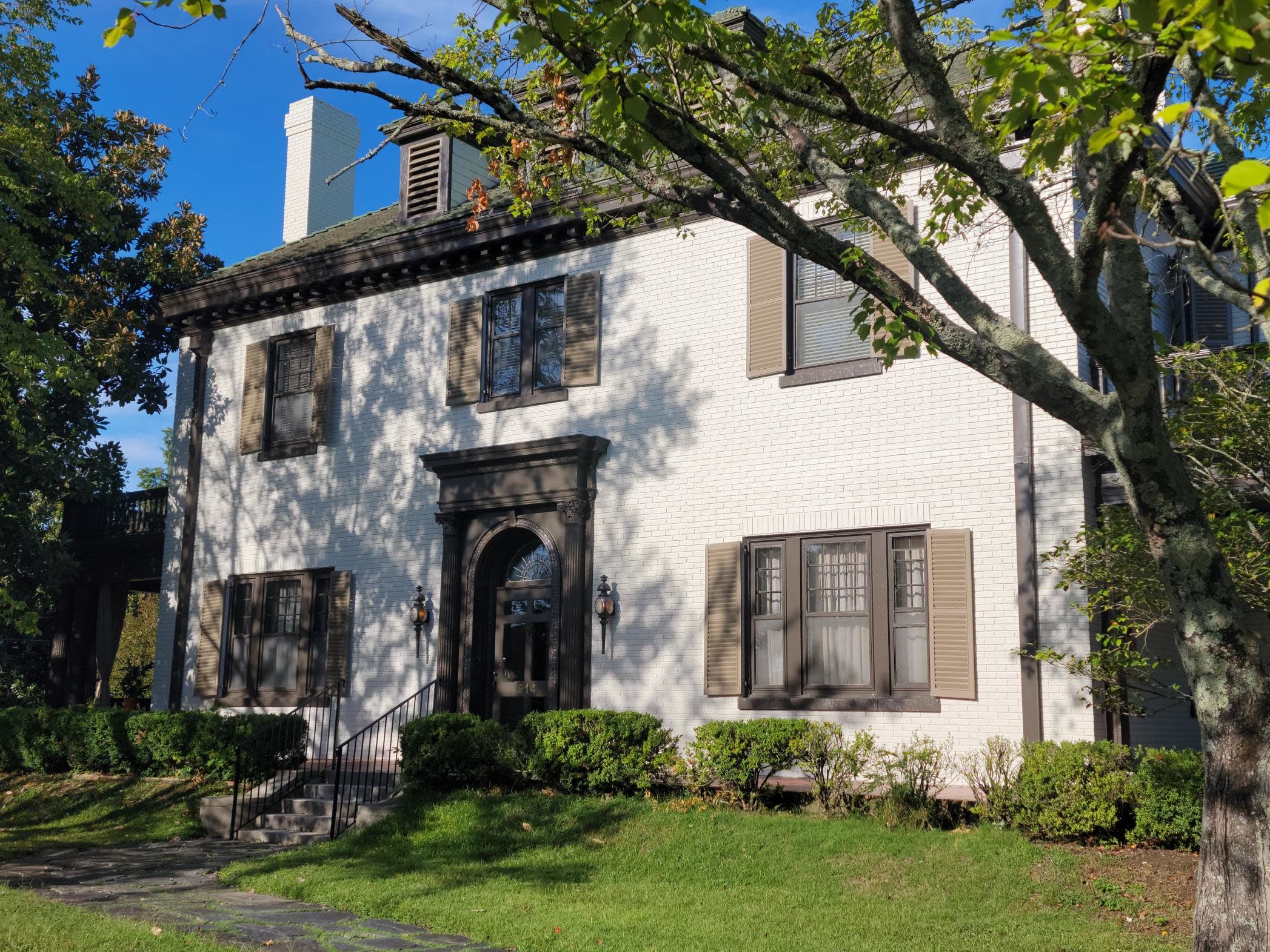 Front view of Victorian Cream Brick mansion with Beige and Brown accents