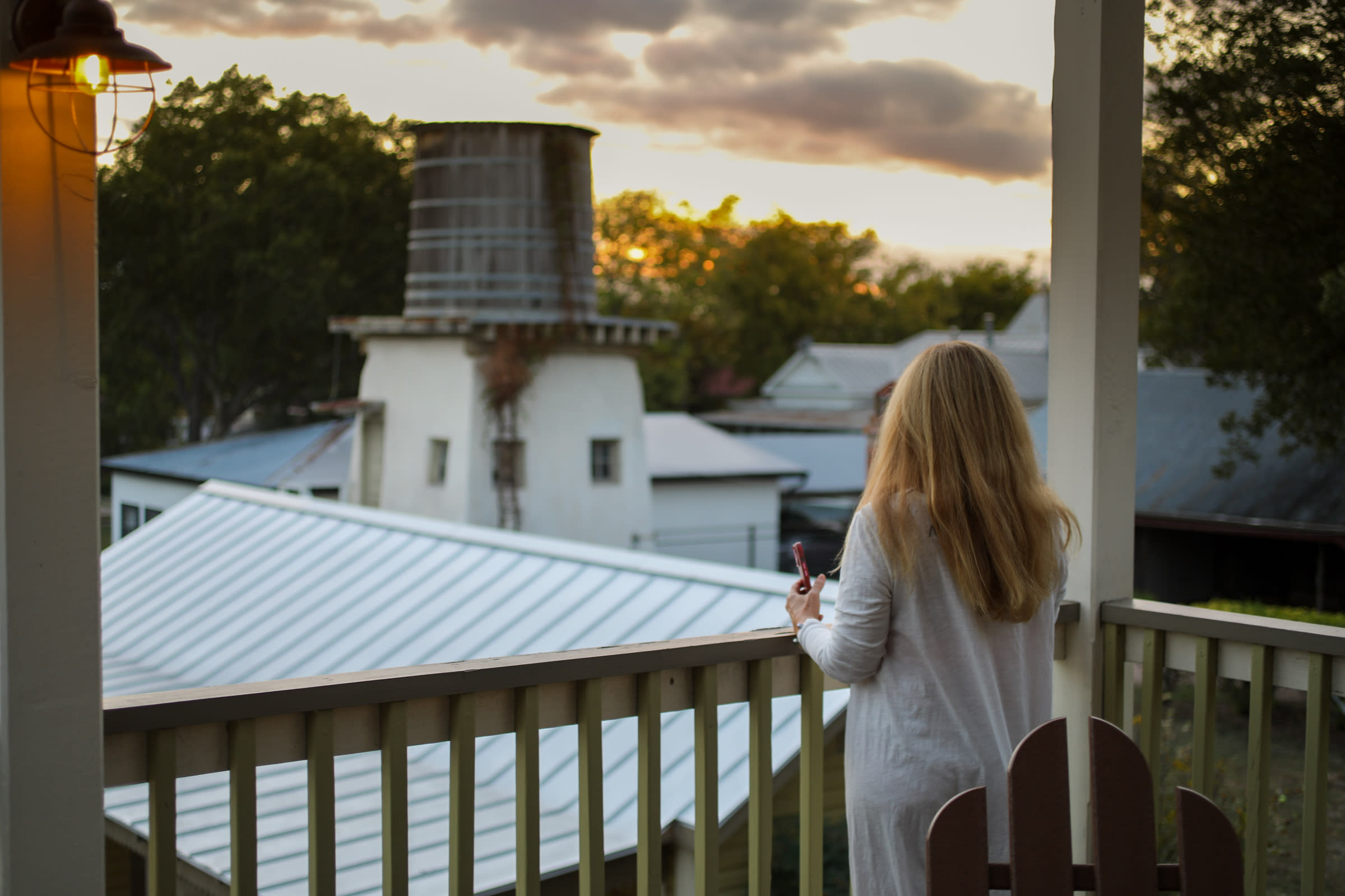 woman look out over building and water tower
